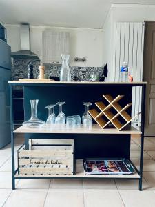 a shelf with glasses and vases on it in a kitchen at "Le studio Bouddha" Studio avec terrasse, centre ville, proche gare, by PRIMO C0NCIERGERIE in Nevers +17 photos