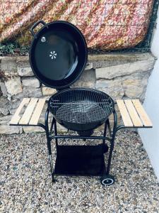 a grill sitting on a bench next to a wall at "Le studio Bouddha" Studio avec terrasse, centre ville, proche gare, by PRIMO C0NCIERGERIE in Nevers