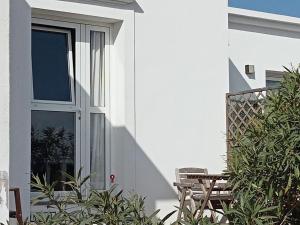 a white house with a door and a table and chairs at Quintero Suites in San Bartolomé