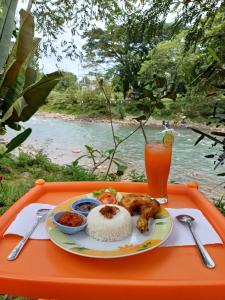 a tray with a plate of food and a drink at Asim Paris Guesthouse in Bukit Lawang