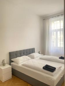 um quarto branco com uma cama grande e uma janela em Home Sweet Home Vienna - Penthouse em Viena
