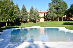 a swimming pool in a yard with trees and a building at Oasis rural in Los Pastores