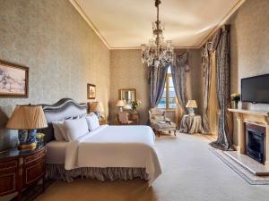 - une chambre avec un grand lit blanc et une cheminée dans l'établissement Sofitel Winter Palace Luxor, à Louxor