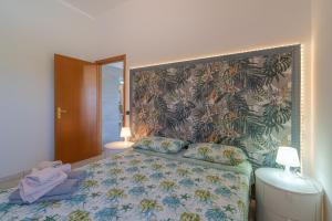 Un dormitorio con una cama con papel pintado floral. en Cascina di Barone - Vista mare, en Noto 20 fotos más
