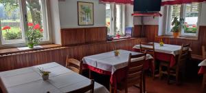 a dining room with tables and chairs and windows at Turisticna Kmetija Psnak in Mojstrana