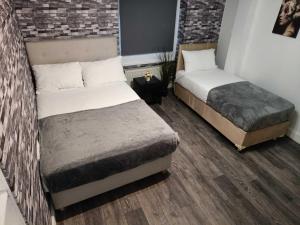 een slaapkamer met 2 bedden en een bakstenen muur bij Comfortable Budget Two Bedroom Apartment In City Centre - Kings Cross - Euston Station - 6 People in Londen
