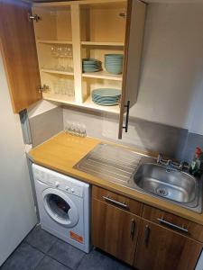 a small kitchen with a sink and a washing machine at Comfortable Budget Two Bedroom Apartment In City Centre - Kings Cross - Euston Station - 6 People in London