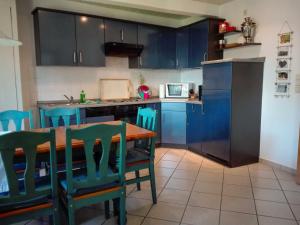 a kitchen with blue cabinets and a table and chairs at Ferienwohnung Paul in der Rostocker Heide in Blankenhagen