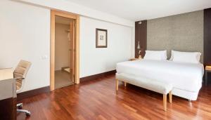 1 dormitorio con cama, escritorio y silla en NH Barcelona Stadium en Barcelona