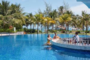 a group of children playing in a pool at a resort at Best Western Premier Sonasea Phu Quoc in Phú Quốc