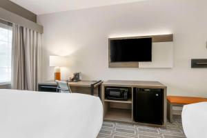 a hotel room with a bed and a flat screen tv at Comfort Inn & Suites Port Charlotte-Punta Gorda in Port Charlotte
