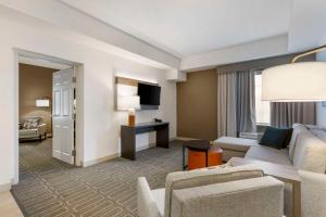 a living room with a couch and a tv at Comfort Inn & Suites Port Charlotte-Punta Gorda in Port Charlotte