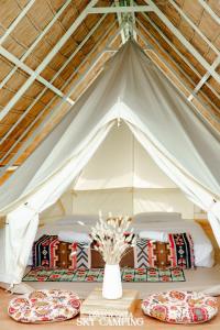Tienda blanca con 2 camas y un jarrón de flores en Tawaen Caza Sky Camping, en Koh Larn