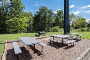 drie picknicktafels en een grill in een park bij Days Inn and Suites by Wyndham Oxford in Oxford