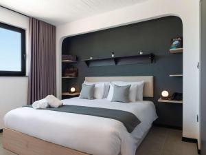 - une chambre avec un grand lit et un mur noir dans l'établissement Aparthotel Adagio Malta Central, à Msida