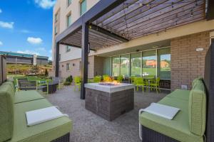 een patio met tafels en stoelen en een vuurplaats bij Home2 Suites By Hilton Cookeville in Cookeville