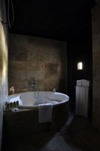 Habitación oscura con baño con bañera. en HOTEL PALACIO DE MENGIBAR, en Mengíbar