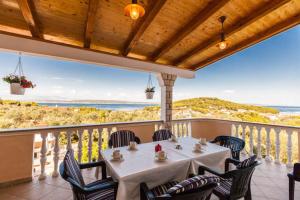 een tafel op een balkon met uitzicht op de oceaan bij Apartments Villa Bosotina in Kukljica