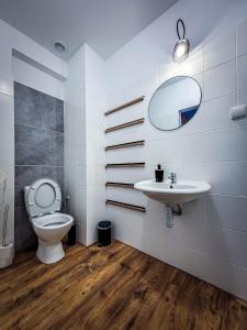 een badkamer met een toilet, een wastafel en een spiegel bij Ośrodek Sportowo-Wypoczynkowy in Choszczno