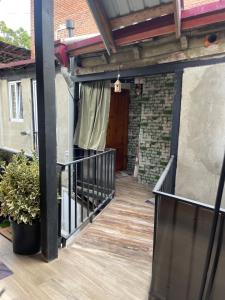 an outdoor deck with a wooden railing and a door at kushki's home in Tbilisi City