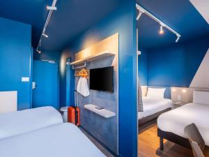 ein Hotelzimmer mit 2 Betten und einem TV in der Unterkunft ibis budget Nantes Nord Treillières in Treillières