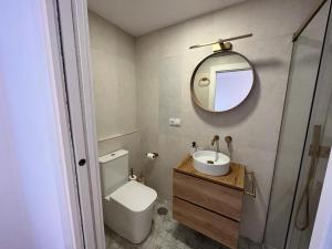 y baño con aseo, lavabo y espejo. en Apartamento jontoya1 en Jaén