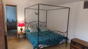 um quarto com uma cama de dossel preta com lençóis azuis em Belle maison 140 m2 à 15 mn de la mer Montpellier em Teyran