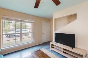 a living room with a flat screen tv and a large window at Killeen Serene in Killeen