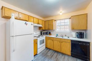 uma cozinha com armários de madeira e um frigorífico branco em Killeen Serene em Killeen