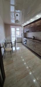 a large kitchen with a table and a dining room at Затишна квартира з виглядом на парк in Ternopilʼ