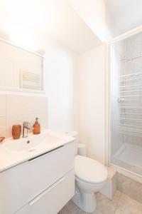 a white bathroom with a toilet and a shower at Le Carlier d'Enghien - 2 chambres - Près du Lac in Enghien-les-Bains