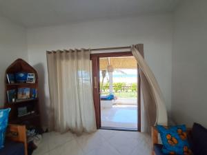 a living room with a sliding glass door to a patio at Casa do Índico in Praia do Tofo