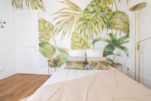 een slaapkamer met een bed met een muurschildering van planten bij Le Carlier d'Enghien - 2 chambres - Près du Lac in Enghien-les-Bains