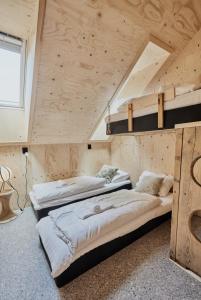 two beds in a room with wooden ceilings at Lodgen Stryn in Stryn
