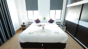 una camera da letto con un grande letto bianco con fiori di Bouasavan Hotel and Garden a Savannakhet