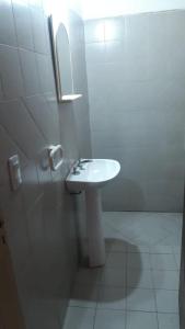 een witte badkamer met een wastafel en een spiegel bij Richard in Mina Clavero