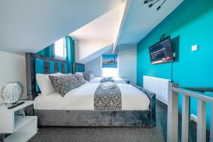 a bedroom with a bed with a blue accent wall at *1ES* For your most relaxed & Cosy stay + Free Parking + Free Fast WiFi * in Leeds