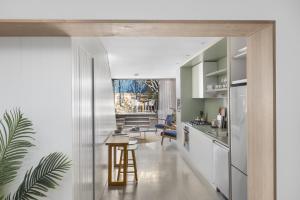 a kitchen with white cabinets and a table in a room at BRID112G - Urban Serenity in Sydney