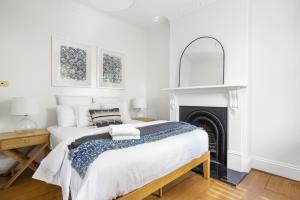 a white bedroom with a bed and a fireplace at BRID112G - Urban Serenity in Sydney