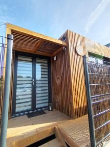 a house with a wooden deck with a fence at La Cabane de Camille 