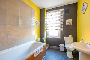 a bathroom with a tub and a toilet and a sink at *1ES* For your most relaxed & Cosy stay + Free Parking + Free Fast WiFi * in Leeds