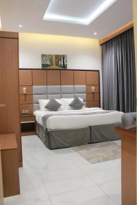 a bedroom with a large bed with a wooden headboard at Five Season Hotel in Al Khobar