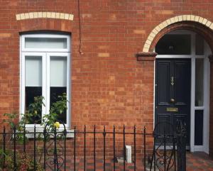 a brick house with a black door and a window at Dublin 6 Rathgar 3km to downtown in Rathgar