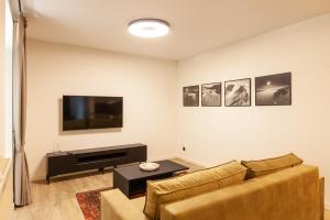 Una sala de estar con un sofá y un televisor de pantalla plana. en Cozy apartment in the old town of Klaipėda on the first floor with free parking, en Klaipėda