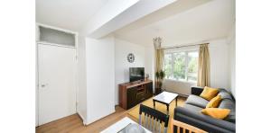 uma sala de estar com um sofá e uma televisão em Entire Two Bedroom Flat in the heart of Greater London em Londres