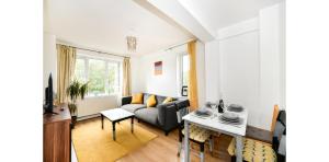 een woonkamer met een bank en een tafel bij Entire Two Bedroom Flat in the heart of Greater London in Londen