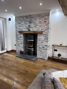 a living room with a brick fireplace and a couch at Modern Newly Renovated 3 Story House in Ebbw Vale in Ebbw Vale