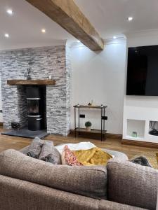 a person laying on a couch in a living room with a fireplace at Modern Newly Renovated 3 Story House in Ebbw Vale in Ebbw Vale