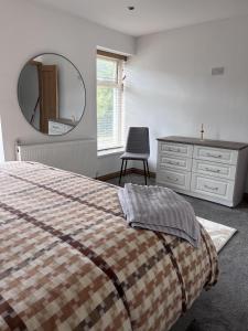 a bedroom with a bed and a dresser and a mirror at Modern Newly Renovated 3 Story House in Ebbw Vale in Ebbw Vale