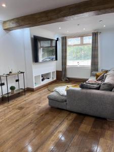 a living room with a couch and wooden floors at Modern Newly Renovated 3 Story House in Ebbw Vale in Ebbw Vale